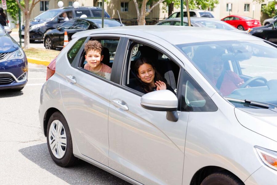kids in car waving